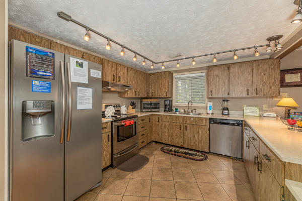 Kitchen with stainless steel appliances and track lighting at Buena Vista Getaway, 3 bedroom cabin rental located in Gatlinburg