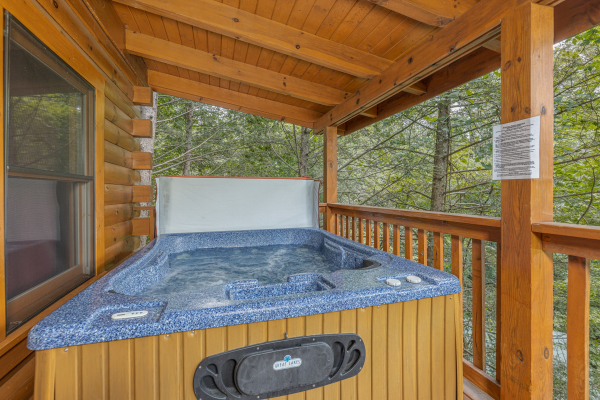 Hot tub on a covered deck at Cub's Crossing, a 3 bedroom cabin rental located in Gatlinburg