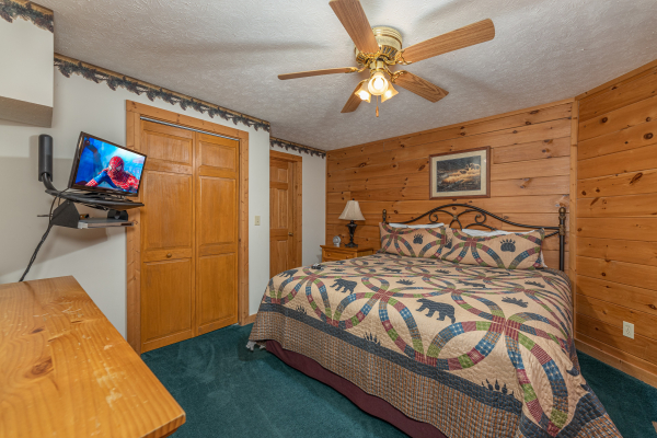 King bed, night stand, lamp, and TV in a bedroom at Cub's Crossing, a 3 bedroom cabin rental located in Gatlinburg