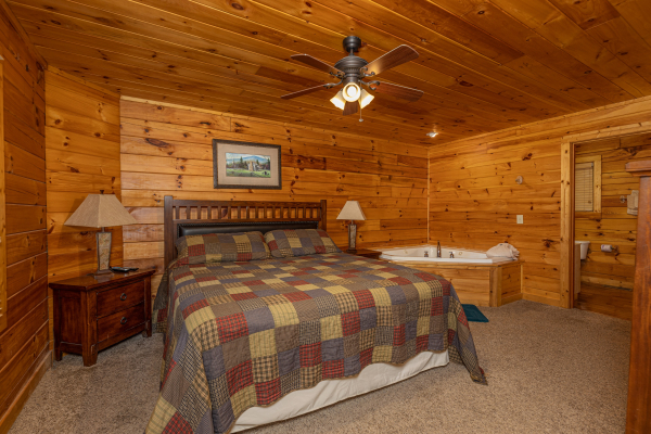 Bedroom with two night stands, lamps, and a jacuzzi at Bearway to Heaven, a 2 bedroom cabin rental located in Gatlinburg