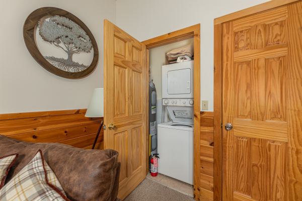 Stacked washer and dryer in a bedroom at Honeysuckle Hideaway, a 1 bedroom cabin rental located in Pigeon Forge