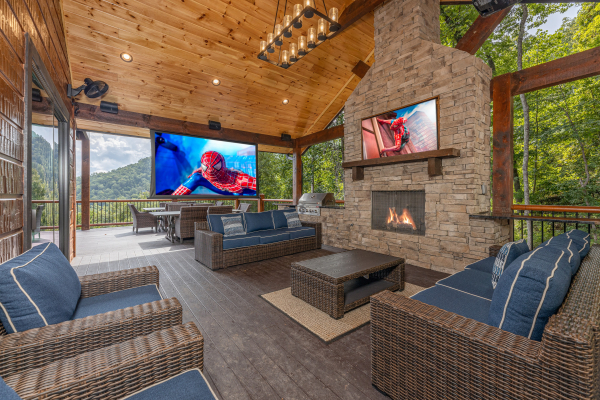 Deck seating area with an outdoor theater projector at Black Bears & Biscuits Lodge, a 6 bedroom cabin rental located in Pigeon Forge