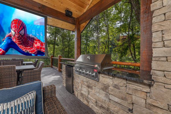 Theater screen and outdoor kitchen at Black Bears & Biscuits Lodge, a 6 bedroom cabin rental located in Pigeon Forge