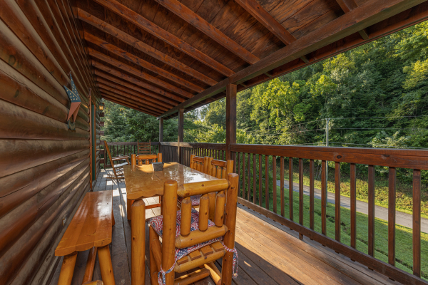 Outdoor dining space on a covered deck at Family Getaway, a 4 bedroom cabin rental located in Pigeon Forge