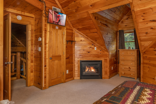 Fireplace and TV in a bedroom at Family Getaway, a 4 bedroom cabin rental located in Pigeon Forge
