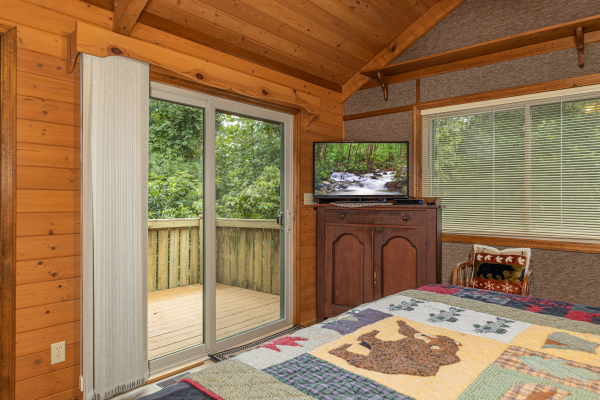 TV and deck access in a bedroom at Cubs' Crib, a 3 bedroom cabin rental located in Gatlinburg