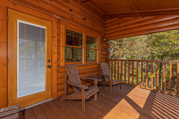 Adirondack chairs on a covered deck at Sensational Views, a 3 bedroom cabin rental located in Gatlinburg