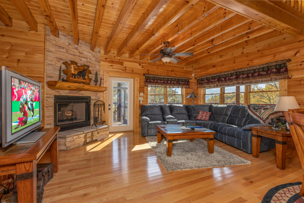 Living room with fireplace, TV, and sectional sofa at Sensational Views, a 3 bedroom cabin rental located in Gatlinburg