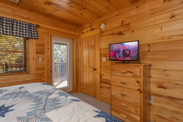 Dresser, TV, and deck access in a bedroom at Sensational Views, a 3 bedroom cabin rental located in Gatlinburg