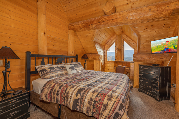 Bedroom with a king bed, night stands, dresser, TV, and views at Grizzly's Den, a 5 bedroom cabin rental located in Gatlinburg
