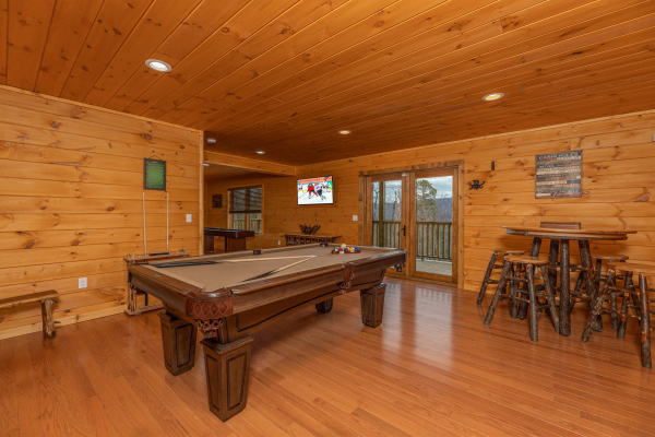 Pool table and high top table in the game room at J's Hideaway, a 4 bedroom cabin rental located in Pigeon Forge