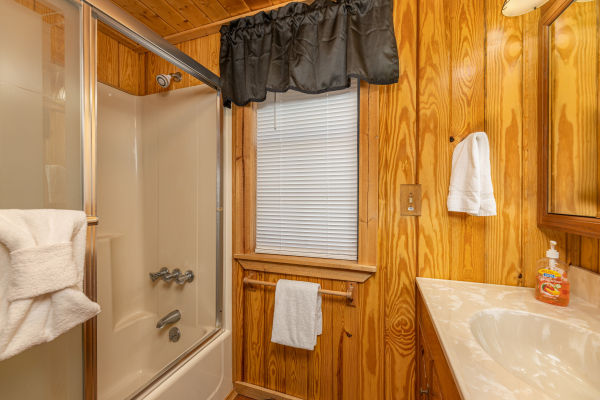 Bathroom with a tub and shower at A Mountain Hyde-a Way, a 2 bedroom cabin rental located in Pigeon Forge
