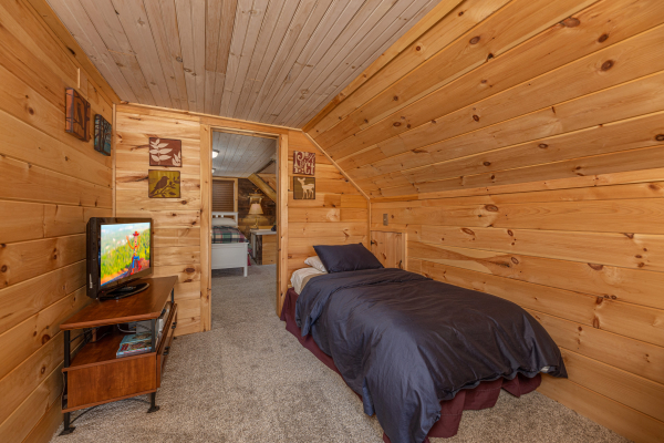 Twin bed and tv at A Mountain Hyde-a Way, a 2 bedroom cabin rental located in Pigeon Forge