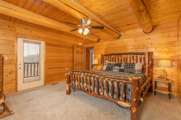 Bedroom with a king log bed, two night stands, and lamps at Smoky Mountain Escape, a 3 bedroom cabin rental located in Pigeon Forge