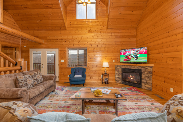 Seating, fireplace, and TV in a living room at Smoky Mountain Escape, a 3 bedroom cabin rental located in Pigeon Forge