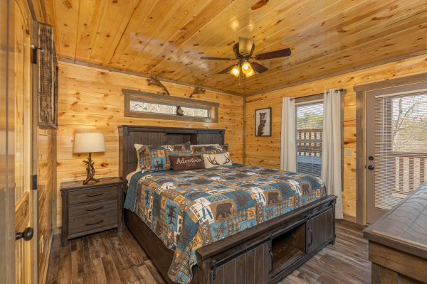Bedroom with night stand, lamp, and deck access at Everly's Splash, a 4 bedroom cabin rental located in Pigeon Forge