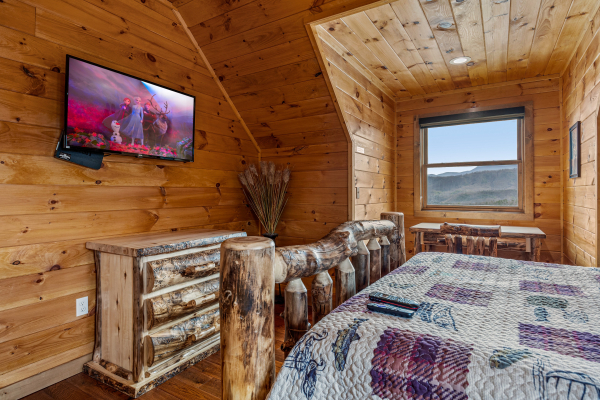 Bedroom with log bed, flat screen, and log dresser at Four Seasons Grand, a 5 bedroom cabin rental located in Pigeon Forge