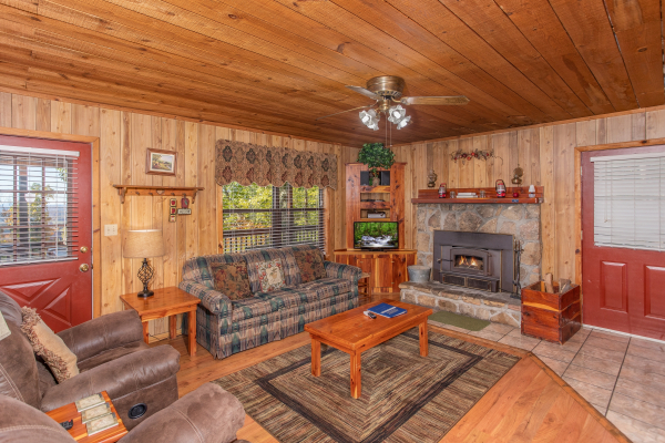 Living room with stone fireplace, couch, and recliners at Apple View, a 2 bedroom cabin rental located in Pigeon Forge