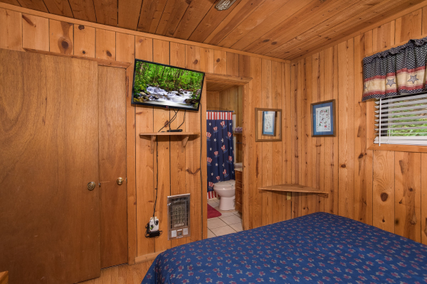 bedroom with a wall mounted television and attached bath at america's view a 2 bedroom cabin rental located in pigeon forge