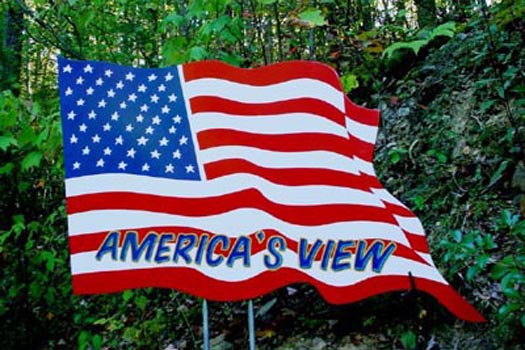 a custom american flag with cabin name signage at america's view a 2 bedroom cabin rental located in pigeon forge