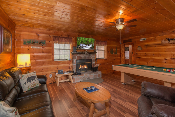 Living room with fireplace and TV at Beary Good Time, a 1-bedroom cabin rental located in Pigeon Forge