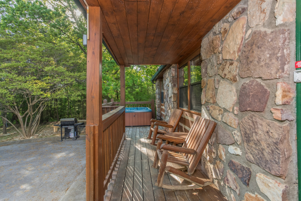 Porch with rocking chairs and a hot tub near a grill at Patriot Pointe, a 5 bedroom cabin rental located in Pigeon Forge