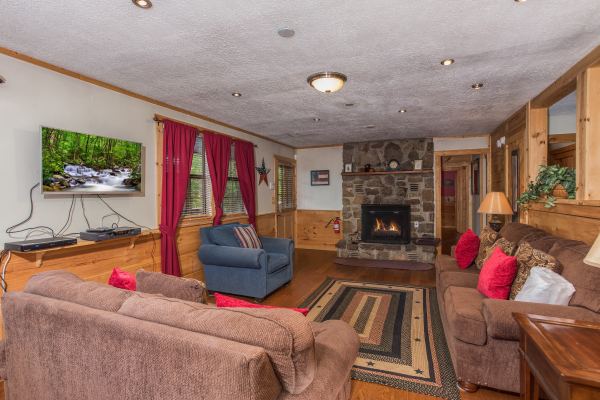 Living room with TV, fireplace, and seating at Patriot Pointe, a 5 bedroom cabin rental located in Pigeon Forge