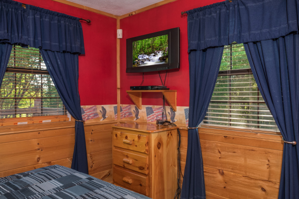 Bedroom with a dresser and TV at Patriot Pointe, a 5 bedroom cabin rental located in Pigeon Forge