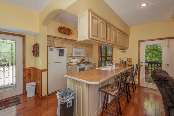 Breakfast bar and kitchen with white appliances at Amazing Memories, a 3 bedroom cabin rental located in Pigeon Forge