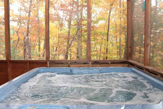 Hot tub on a screened in deck at Little Bear, a 1 bedroom cabin rental located in Pigeon Forge