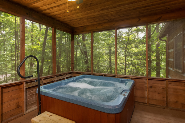 Hot tub on a screened in porch at Little Bear, a 1 bedroom cabin rental located in Pigeon Forge