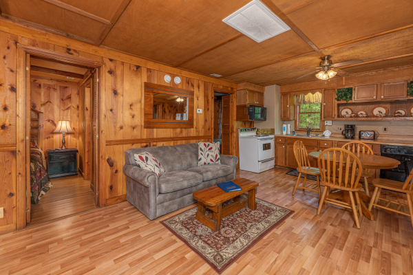 Living room with loveseat and dining table for four at Heavenly Hideaway, a 2-bedroom cabin rental located in Gatlinburg