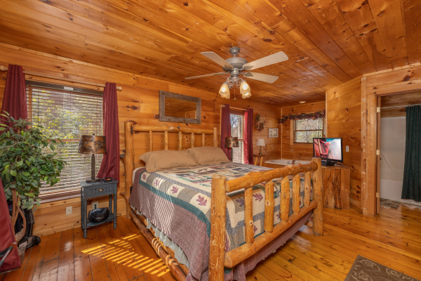 Bedroom with night stands, lamps, and TV at Fallin' in Love, a 1 bedroom cabin rental located in Gatlinburg