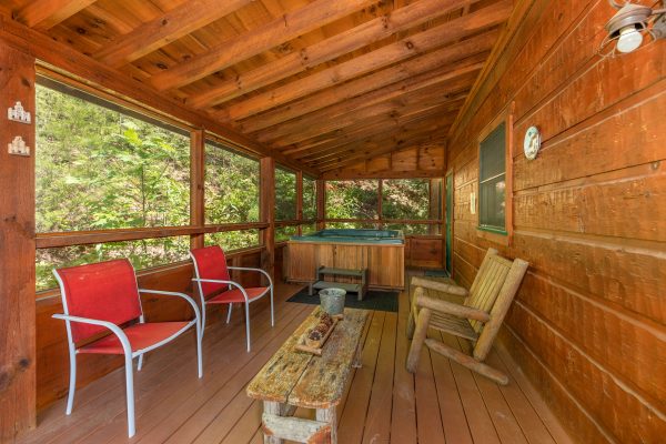 Deck seating and a hot tub on a covered deck at Eagle's Loft, a 2 bedroom cabin rental located in Pigeon Forge