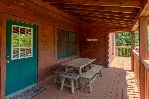 Picnic table on a covered deck at Eagle's Loft, a 2 bedroom cabin rental located in Pigeon Forge