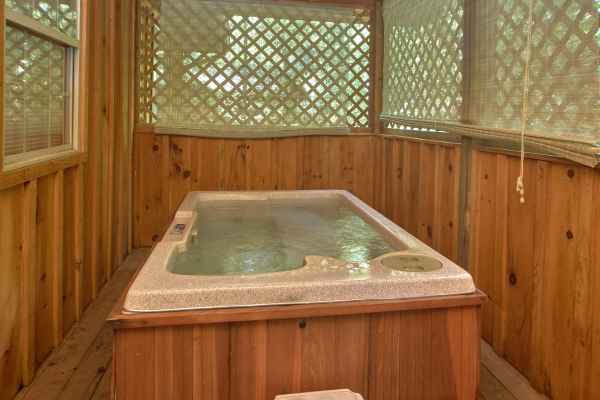 Hot tub on a covered deck with privacy fencing at Dream Catcher, a 1-bedroom cabin rental located in Pigeon Forge