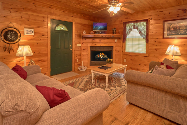Living room with fireplace and television at Dream Catcher, a 1-bedroom cabin rental located in Pigeon Forge