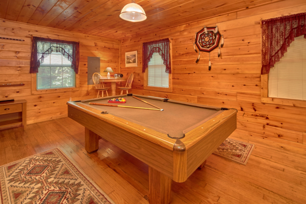 Pool table and a high top table in the game space at Dream Catcher, a 1-bedroom cabin rental located in Pigeon Forge