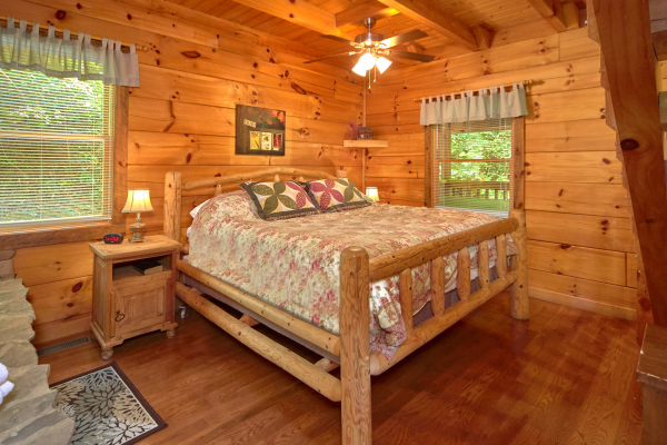 King sized log bed on the main floor at Wild Crush, a 1 bedroom cabin rental located in Pigeon Forge