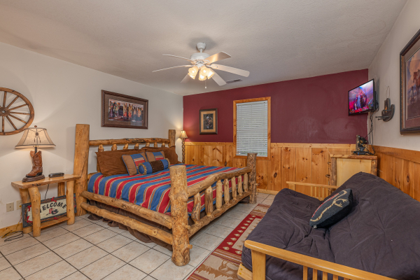 King log bed and a futon on the first floor at Almost Bearadise, a 4 bedroom cabin rental located in Pigeon Forge