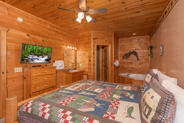Bedroom with jacuzzi, television, dresser, and a sink vanity at Bearly in the Mountains, a 5-bedroom cabin rental located in Pigeon Forge