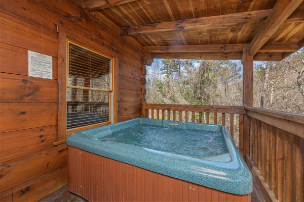 Hot tub on a covered deck at Smoky Bears Creek, a 2 bedroom cabin rental located in Pigeon Forge