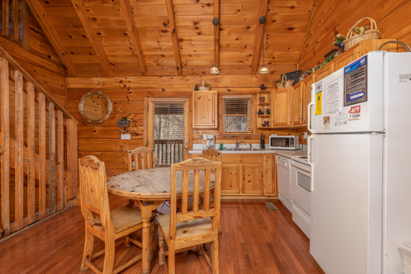 Kitchen with dining table for three and white appliances at Smoky Bears Creek, a 2 bedroom cabin rental located in Pigeon Forge