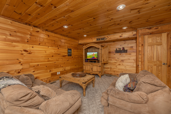 Lower living room with seating and a TV at Smoky Bears Creek, a 2 bedroom cabin rental located in Pigeon Forge