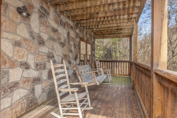 Porch with rocking chairs and a swing at Smoky Bears Creek, a 2 bedroom cabin rental located in Pigeon Forge