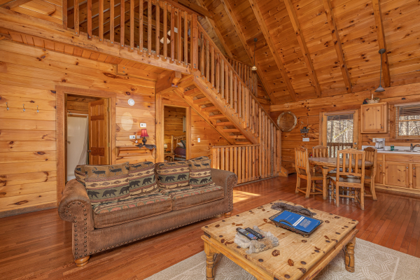 Sofa and dining room and kitchen at Smoky Bears Creek, a 2 bedroom cabin rental located in Pigeon Forge
