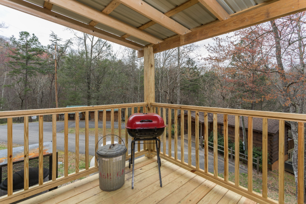 Charcoal grill on a covered deck at Boogie Bear, a 1-bedroom cabin rental located in Gatlinburg
