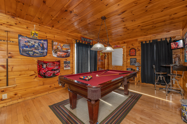 Red felt pool table in a game room at Nascar Nation, a 2 bedroom cabin rental located in Pigeon Forge