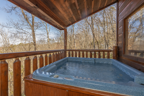 Hot tub on a covered deck at Honey Bear Haven, a 1 bedroom cabin rental located in Pigeon Forge
