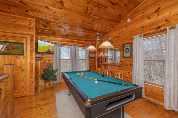 Pool table and TV in the game space at Honey Bear Haven, a 1 bedroom cabin rental located in Pigeon Forge